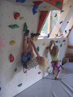 Kinder klettern spielerisch an der Boulderwand